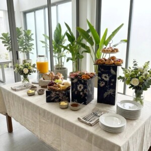 Dark blue floral table risers in three heights displaying gourmet food at an event